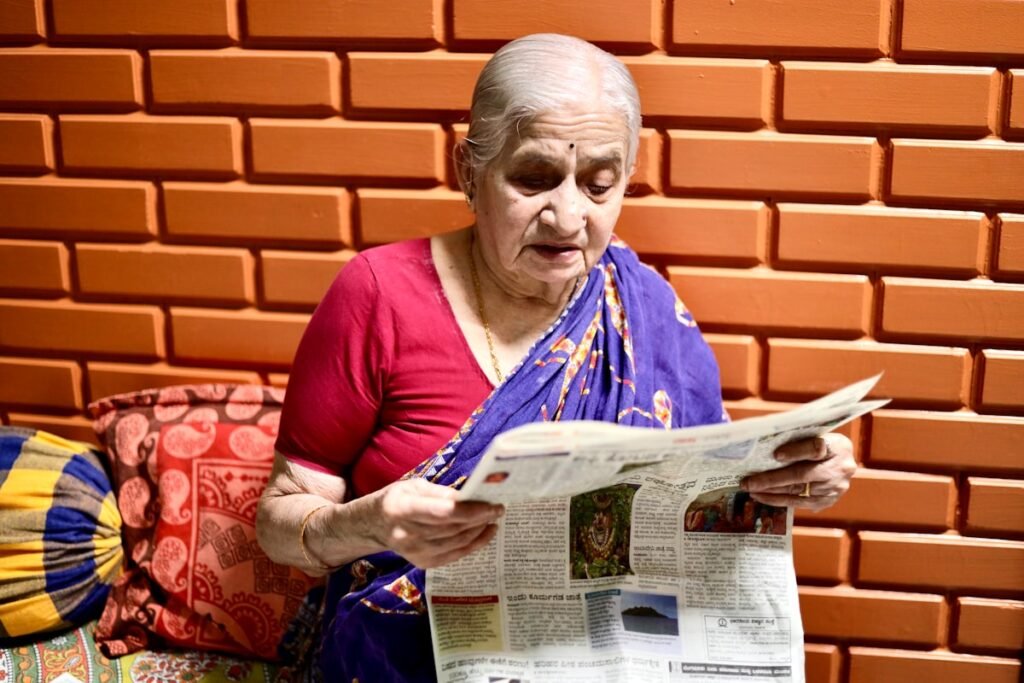 Estimulação cognitiva para idosos: senhora lendo jornal atentamente em casa