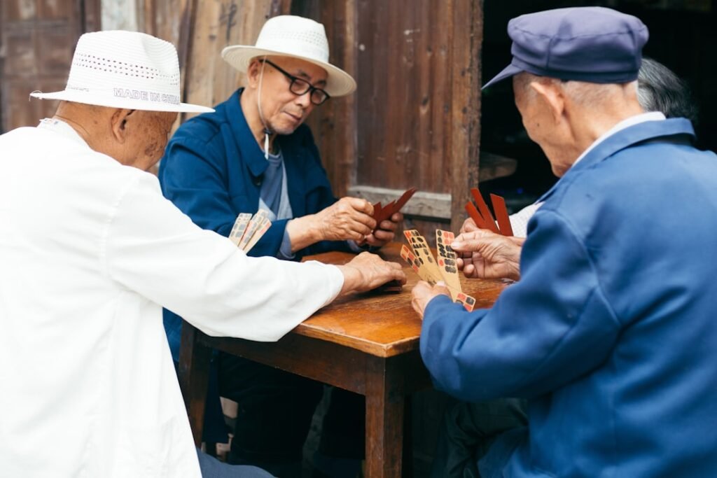 Grupo de amigos concentrados jogando cartas ao redor de uma mesa