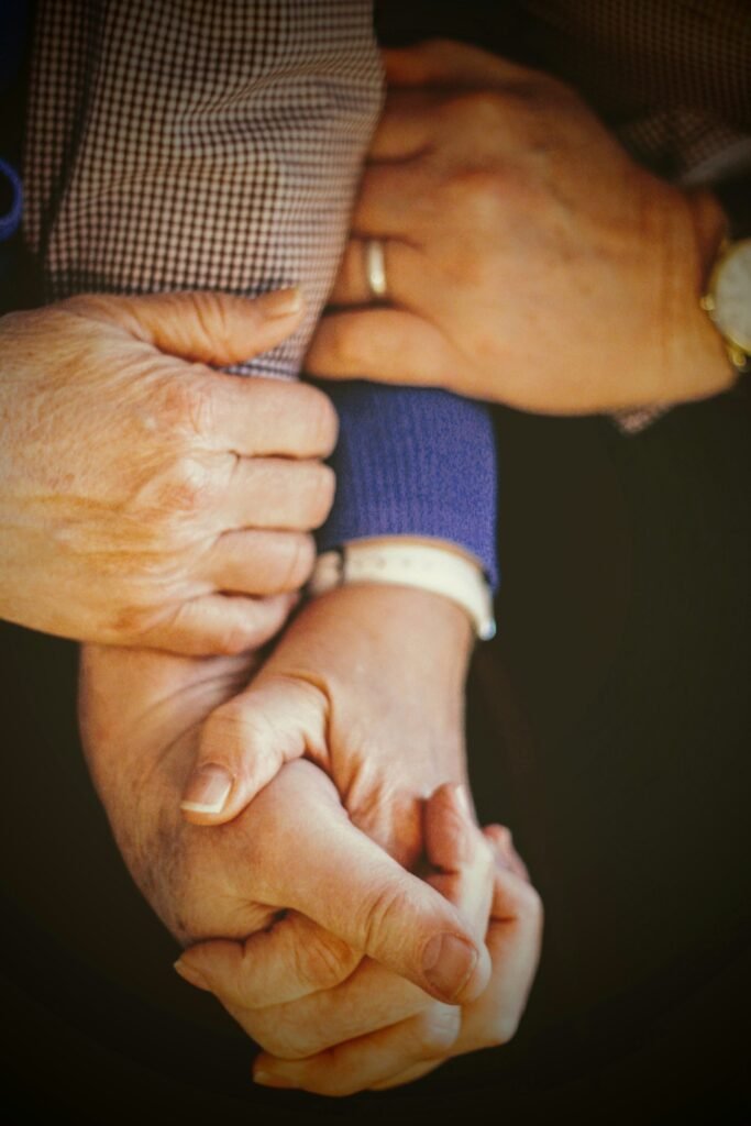 Mãos de um casal de idosos entrelaçadas, simbolizando que o vínculo importa mais que acertar a atividade