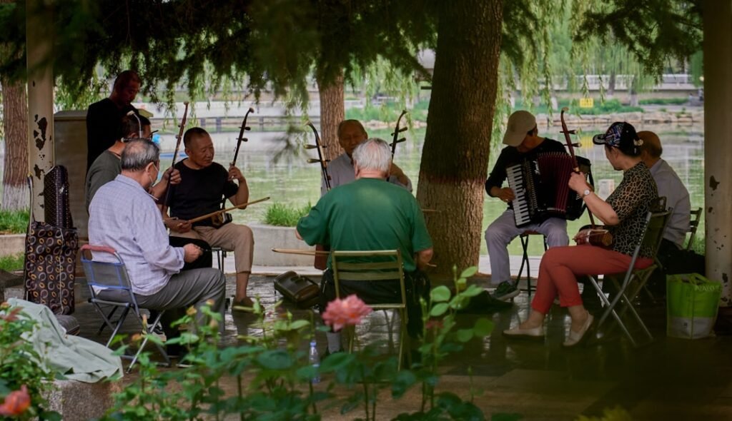 Grupo de idosos reunido ao ar livre tocando instrumentos musicais juntos